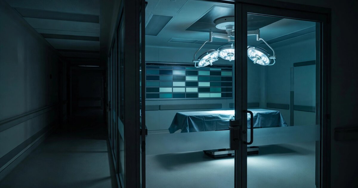 Empty hospital operating room with surgical lights illuminating an unused table